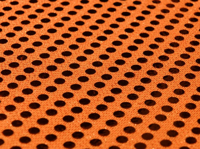 a close up of a metal surface with holes